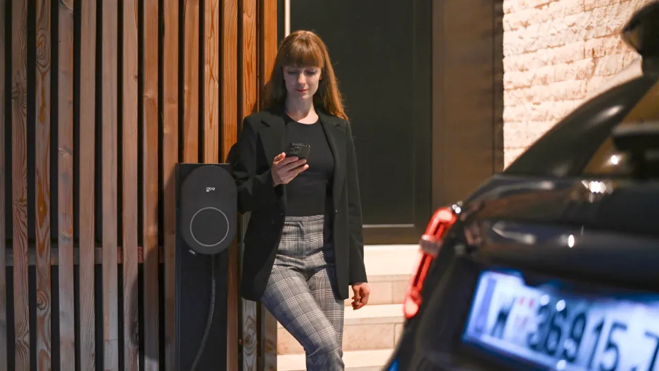 Frau steht neben AFIR-fähigem go-e Charger Core Frau steht neben AFIR-fähigem go-e Charger Core