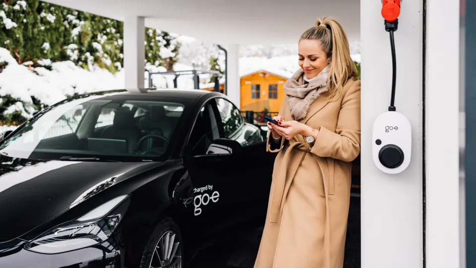 Frau steht bei Wallbox mit RFID-Funktion Frau steht bei Wallbox mit RFID-Funktion
