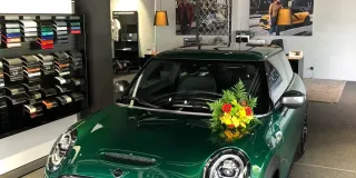 Grüner Mini Cooper SE wird im Autohaus abgeholt.