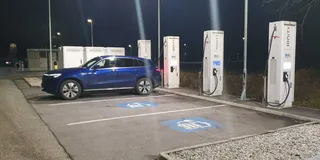 Blauer Mercedes EQC an Ionity Ladesaeule im Ladevorgang bei Nacht.