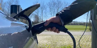 Tesla Model 4 Grau beim Laden am Supercharger. Nahaufname