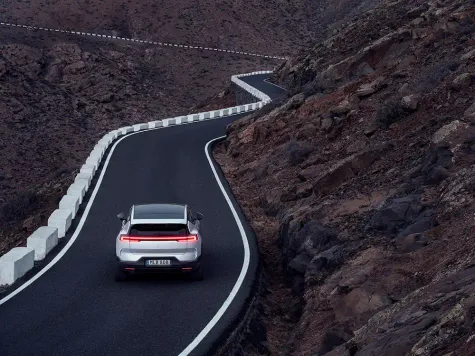 Polestar 3 während der Fahrt von hinten in weiß Polestar 3 während der Fahrt von hinten in weiß