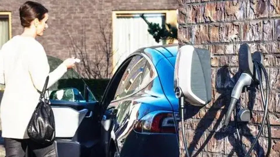 Elektroauto wird zu Hause mit Wallbox geladen - Frau nutzt Ladestation Elektroauto wird zu Hause mit Wallbox geladen - Frau nutzt Ladestation