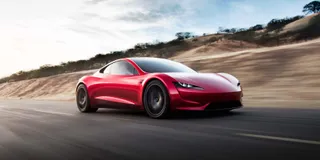 Foto Tesla Roadster in rot von schräg vorne auf einer Strasse