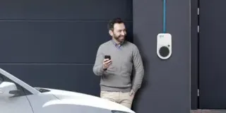 Mann steht vor Charger: Wallbox anschliessen fuer bequemes Laden
