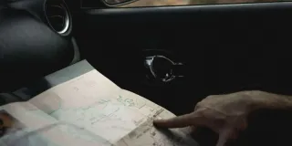 Finger auf Landkarte im E-Auto