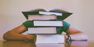 Mensch hinter Bücherstapel