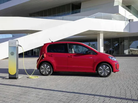 VW e-Up Elektroauto in der Farbe rot Ansicht von der Seite beim Laden an einer Ladesäule VW e-Up Elektroauto in der Farbe rot Ansicht von der Seite beim Laden an einer Ladesäule