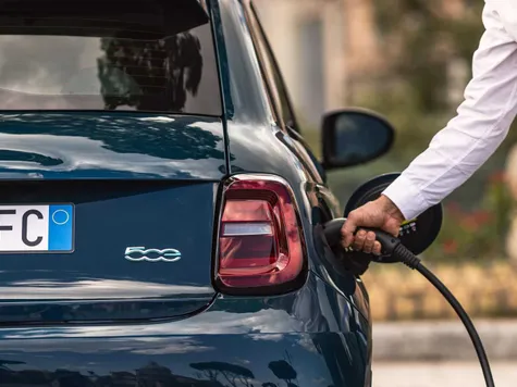 Fiat 500e Elektroauto in der Farbe blaau Ansicht von der Seite bei einer Stadtfahrt Fiat 500e Elektroauto in der Farbe blaau Ansicht von der Seite bei einer Stadtfahrt
