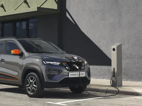 Dacia Spring Electric in der Farbe grau Ansicht Front beim Laden an einer Ladesäule Dacia Spring Electric in der Farbe grau Ansicht Front beim Laden an einer Ladesäule