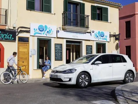 VW e-Golf Elektroauto in der Farbe weiss Ansicht von der Seite bei der Fahrt in der Stadt VW e-Golf Elektroauto in der Farbe weiss Ansicht von der Seite bei der Fahrt in der Stadt