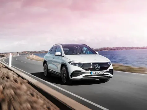 Mercedes Benz EQA weiss Ansicht von schräg Vorne während des Fahrens auf einem Damm Mercedes Benz EQA weiss Ansicht von schräg Vorne während des Fahrens auf einem Damm
