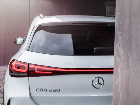 Mercedes Benz EQA weiss Heckansicht hinter Mauer Mercedes Benz EQA weiss Heckansicht hinter Mauer