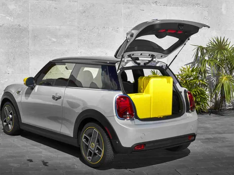 Mini Cooper SE Elektroauto in der Farbe weiss Ansicht beim Laden mit Ladekabel Mini Cooper SE Elektroauto in der Farbe weiss Ansicht beim Laden mit Ladekabel