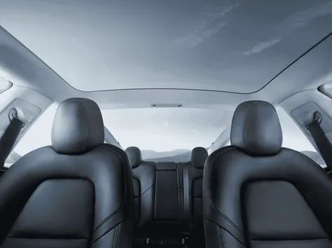 Tesla Model 3 Elektroauto in der Farbe rot Ansicht des Innenraums und der Sitze mit Panoramadach Tesla Model 3 Elektroauto in der Farbe rot Ansicht des Innenraums und der Sitze mit Panoramadach