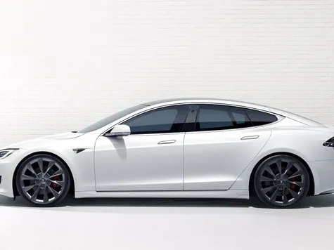 Tesla Model S Elektroauto in der Farbe weiss Ansicht beim Laden an einer Wallbox. Studioaufnahme Tesla Model S Elektroauto in der Farbe weiss Ansicht beim Laden an einer Wallbox. Studioaufnahme