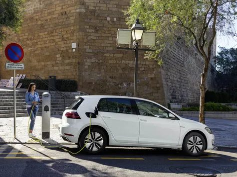 VW e-Golf Elektroauto in der Farbe weiss Ansicht von der Seite beim Laden an einer Ladesäule VW e-Golf Elektroauto in der Farbe weiss Ansicht von der Seite beim Laden an einer Ladesäule